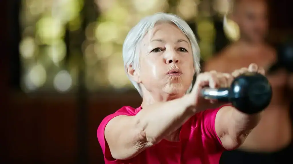 Toning Arms After 60: Empowering Womens Fitness Through Effective Weight Training 1 Older woman doing weight training Solihull to help her strength and longevity