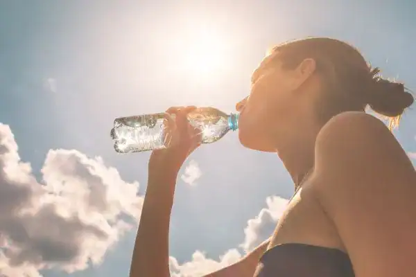 Hydration: The Secret Ingredient for a Toned Stomach and Enhanced Fitness 3 Image of woman drinking water to hydrate Solihull after run.