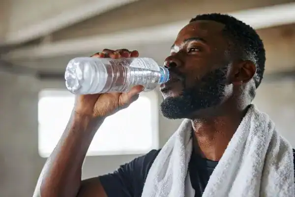 Hydration: The Secret Ingredient for a Toned Stomach and Enhanced Fitness 1 Image of man drinking water to improve hydration Solihull after work out.